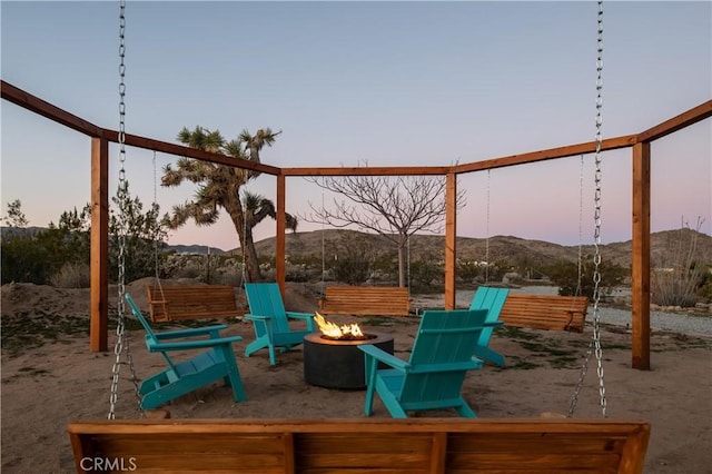 playground at dusk featuring a mountain view and a fire pit