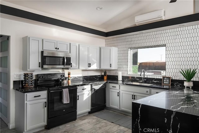 kitchen featuring sink, white cabinetry, black appliances, and a wall unit AC