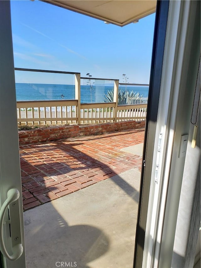 balcony featuring a water view and a beach view