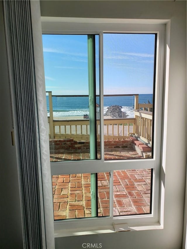 entryway with a beach view, a water view, and a wealth of natural light