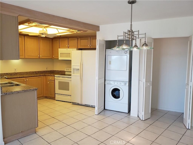 kitchen with sink, hanging light fixtures, stacked washer and dryer, white appliances, and light tile patterned floors