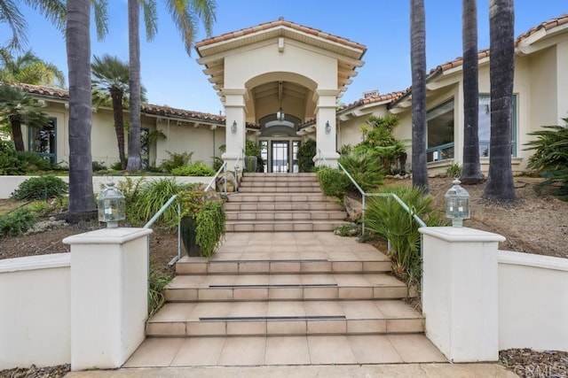 property entrance with a tiled roof and stucco siding
