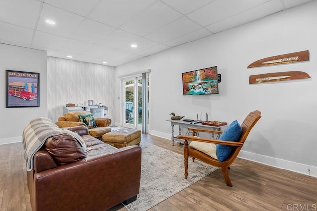 living room with a paneled ceiling, wood finished floors, baseboards, and recessed lighting