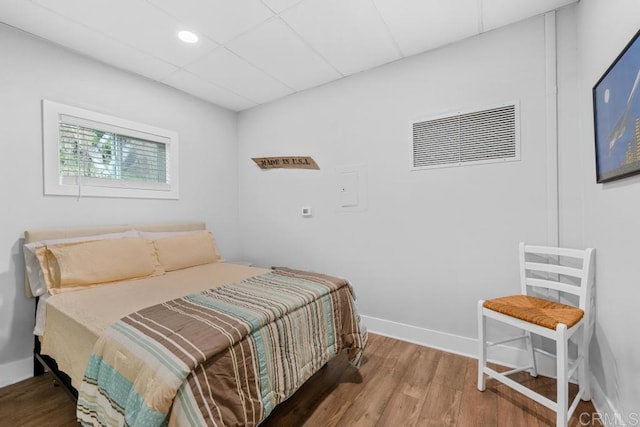 bedroom with visible vents, baseboards, and wood finished floors