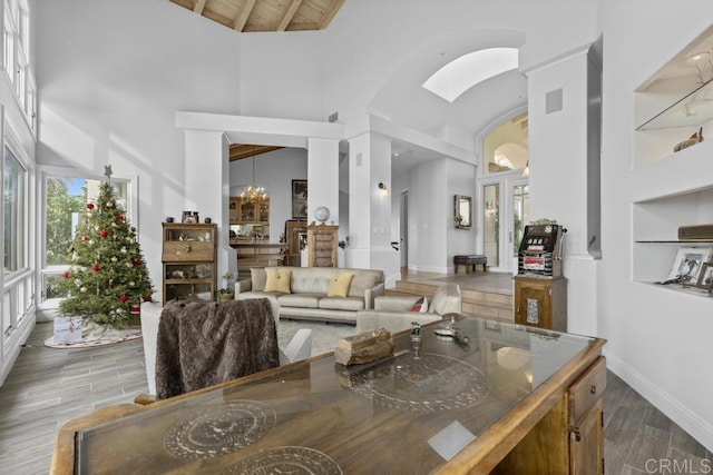 living area with high vaulted ceiling, arched walkways, wooden ceiling, wood finished floors, and beam ceiling