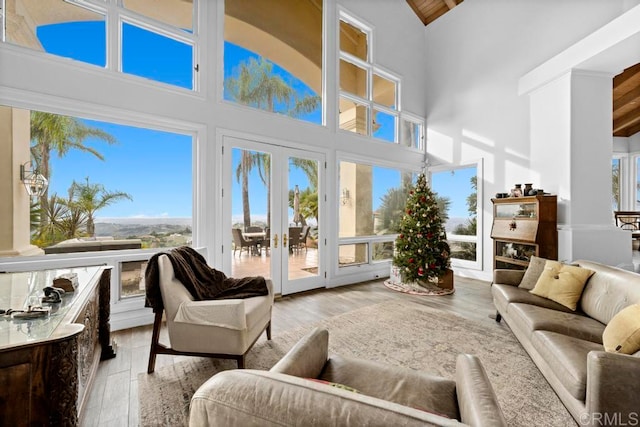 sunroom with lofted ceiling, french doors, and a wealth of natural light