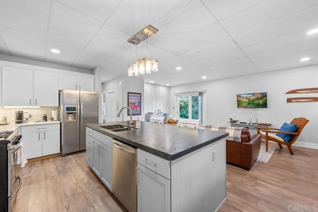 kitchen with pendant lighting, stainless steel appliances, sink, and white cabinetry