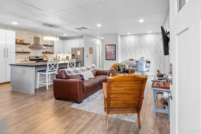 living area featuring visible vents, recessed lighting, and light wood-style floors