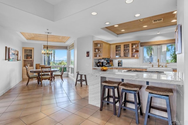 kitchen with plenty of natural light, open shelves, and a raised ceiling