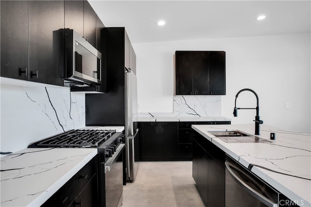 kitchen featuring stainless steel appliances, decorative backsplash, sink, and light stone counters