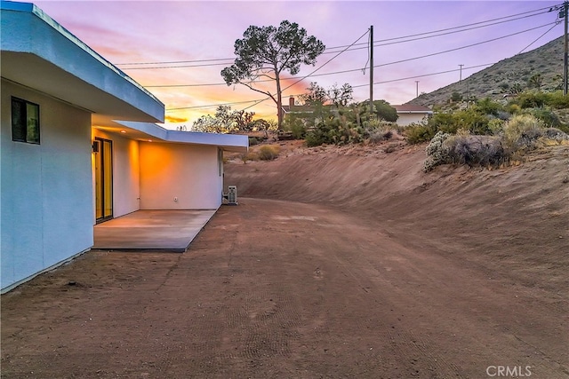 yard at dusk featuring a patio area