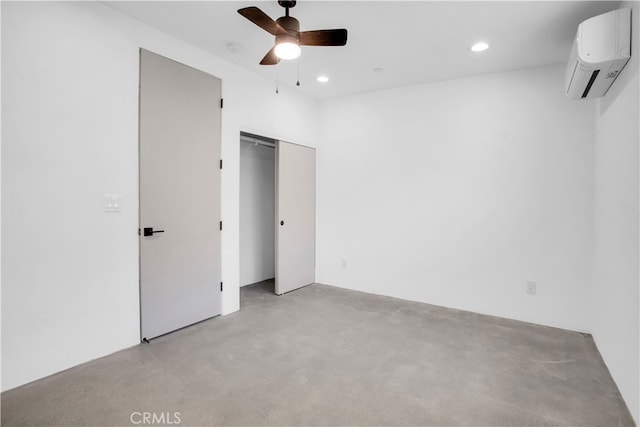 unfurnished bedroom featuring an AC wall unit, ceiling fan, and a closet