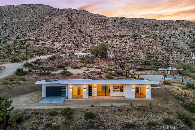 back house at dusk with a mountain view