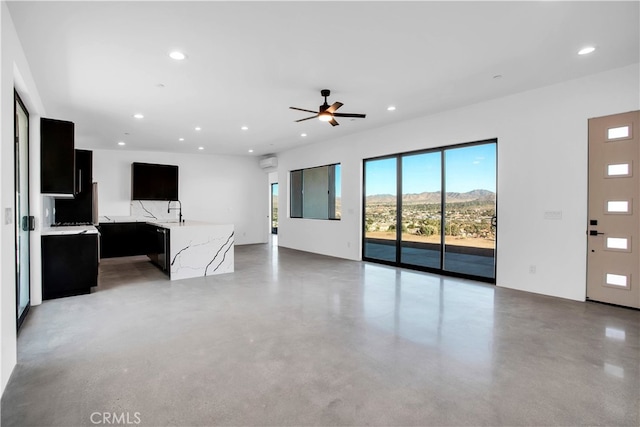 unfurnished living room featuring ceiling fan, a mountain view, and sink