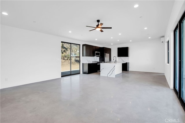 unfurnished living room with ceiling fan and sink