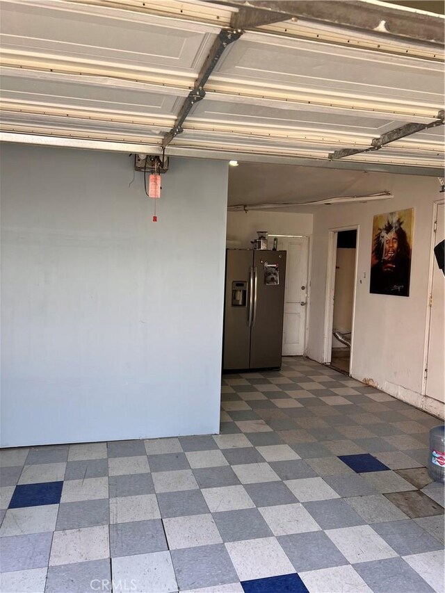 garage featuring stainless steel fridge with ice dispenser