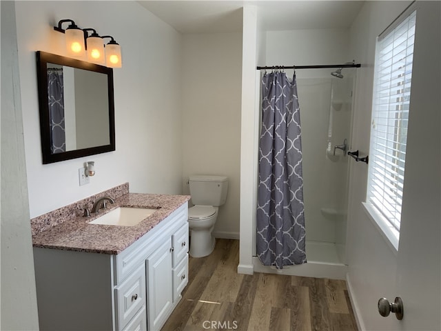 bathroom with vanity, curtained shower, wood-type flooring, and toilet