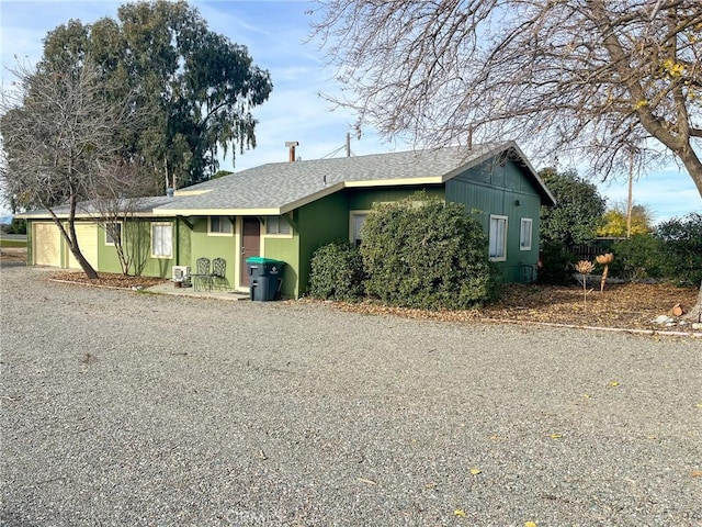 view of front of house with roof with shingles, driveway, and an attached garage