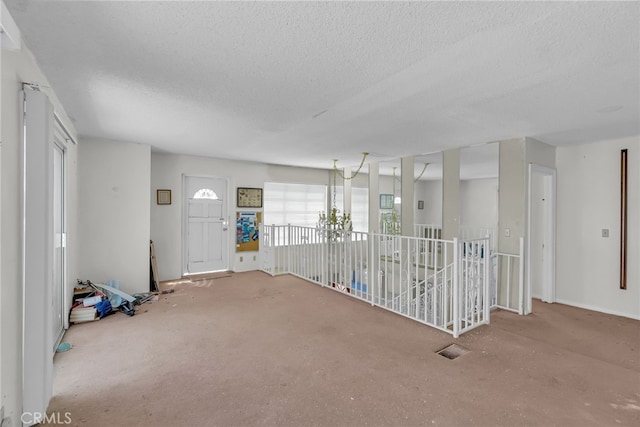 interior space featuring a textured ceiling and carpet floors