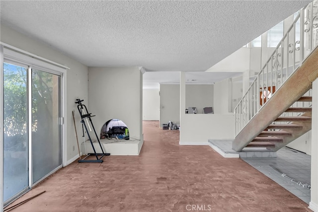 workout area featuring a textured ceiling and baseboards