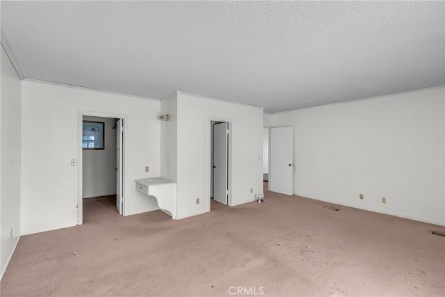 interior space with a textured ceiling and carpet floors