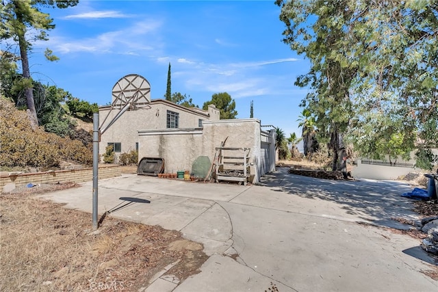 rear view of house with fence, stucco siding, and a patio area