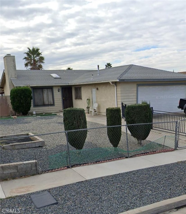 ranch-style home featuring a patio, driveway, an attached garage, stucco siding, and a fenced front yard