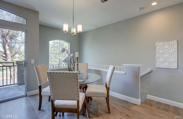 dining space with a notable chandelier and light wood-type flooring