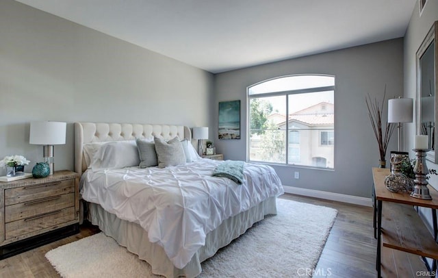 bedroom with dark hardwood / wood-style flooring