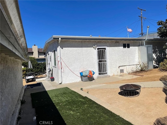 rear view of house with an outdoor fire pit