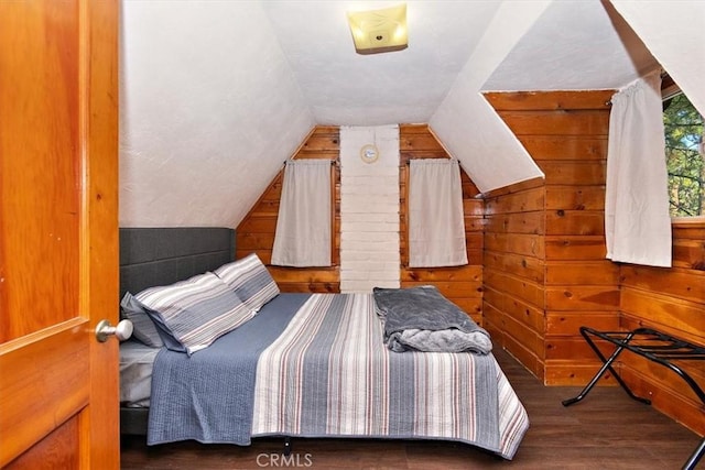 bedroom featuring dark hardwood / wood-style floors, vaulted ceiling, and wooden walls