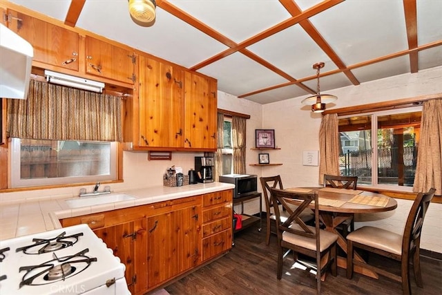 kitchen with white range with gas stovetop, dark hardwood / wood-style floors, tile countertops, and sink