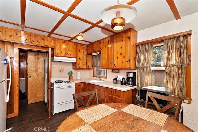 kitchen featuring backsplash, stainless steel appliances, wooden walls, dark wood-type flooring, and sink