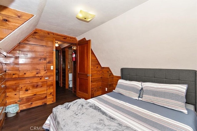 bedroom with vaulted ceiling and dark wood-type flooring