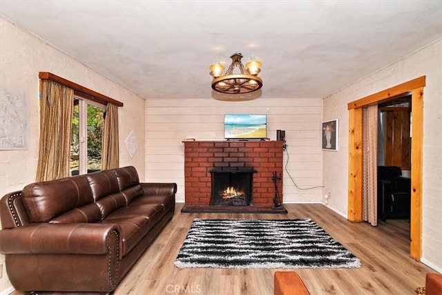 living room with a fireplace, wood-type flooring, and a notable chandelier