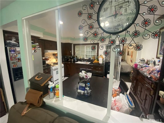 2171 Pomona Ave, Costa Mesa, CA 92627 - kitchen featuring refrigerator with ice dispenser, dark brown cabinetry, white gas range oven, and sink