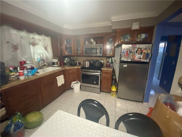 2171 Pomona Ave, Costa Mesa, CA 92627 - kitchen with light tile patterned flooring, appliances with stainless steel finishes, crown molding, and sink