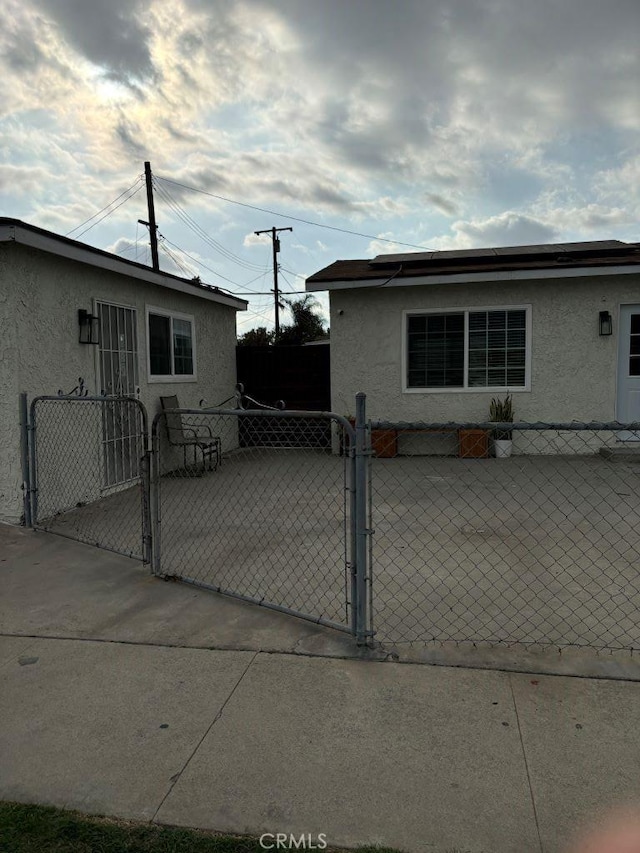 view of property exterior featuring fence, a gate, and stucco siding