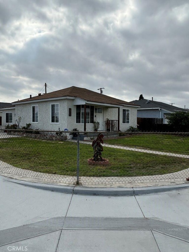 single story home featuring fence, a front lawn, and stucco siding