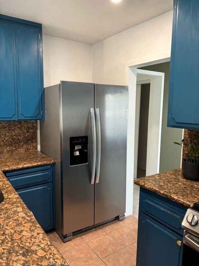 kitchen featuring stainless steel appliances, blue cabinetry, and dark countertops