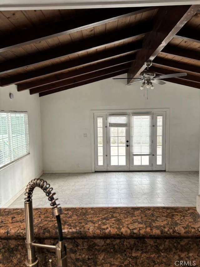 tiled empty room featuring vaulted ceiling with beams, wooden ceiling, and a wealth of natural light