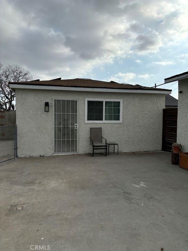 back of house with a patio area, fence, and stucco siding