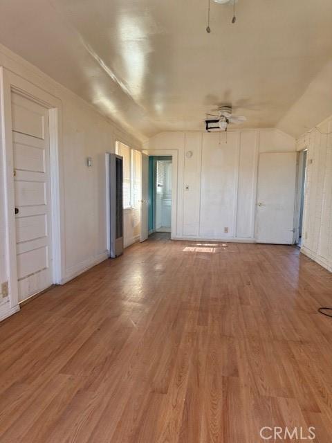 unfurnished living room featuring ceiling fan, light wood-type flooring, and lofted ceiling