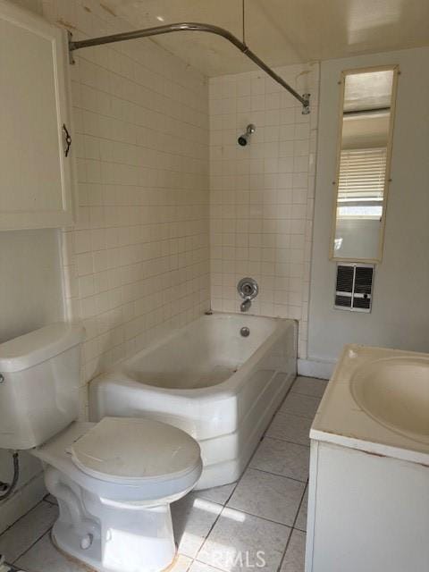 full bathroom featuring tiled shower / bath combo, vanity, toilet, and tile patterned flooring