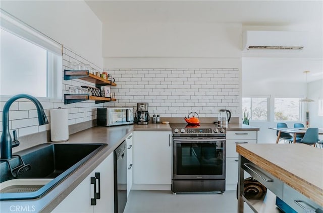 kitchen with tasteful backsplash, stainless steel appliances, a wall unit AC, sink, and white cabinetry