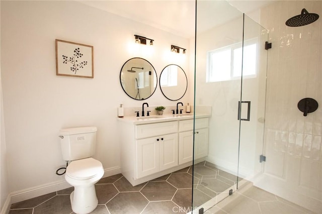 bathroom featuring tile patterned flooring, a shower with door, vanity, and toilet