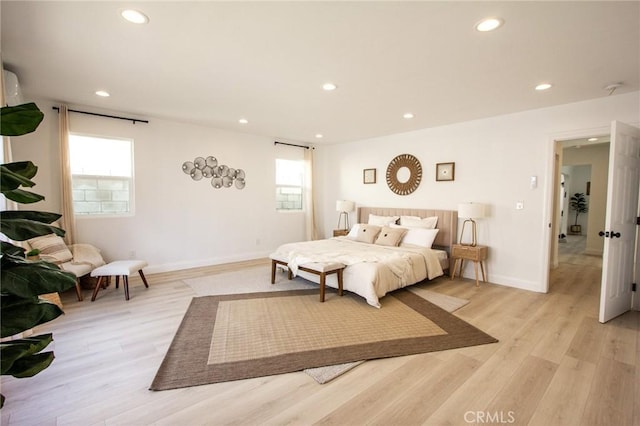 bedroom featuring multiple windows and light hardwood / wood-style flooring