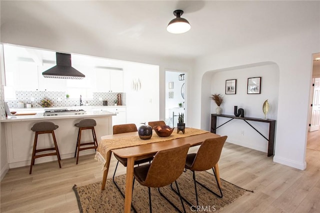 dining space with light wood-type flooring and sink