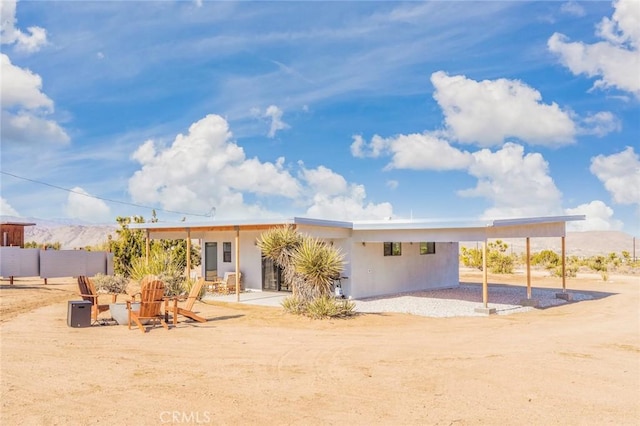 59149 Desert Gold Dr, Yucca Valley, CA 92284 - back of house featuring stucco siding and a mountain view