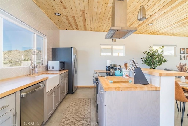 59149 Desert Gold Dr, Yucca Valley, CA 92284 - kitchen with stainless steel appliances, butcher block countertops, extractor fan, wood ceiling, and a kitchen breakfast bar
